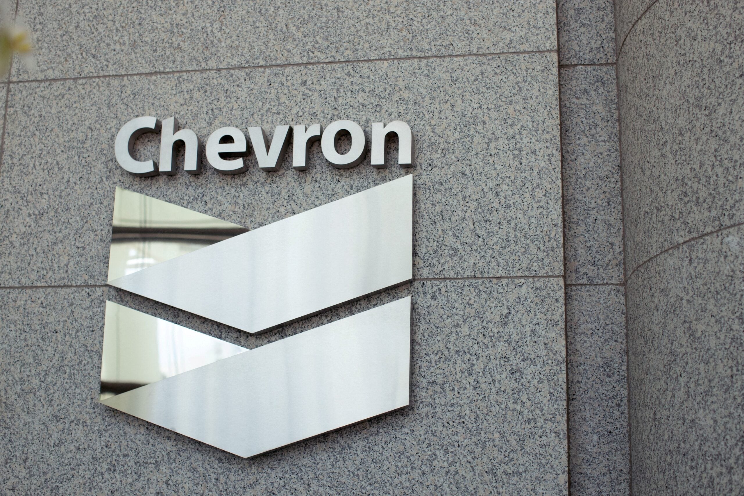Chevron logo and oil infrastructure under clear skies